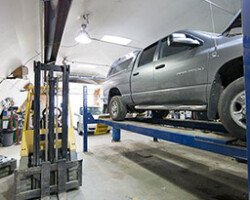 Pickup truck raised on a hoist in auto repair shop